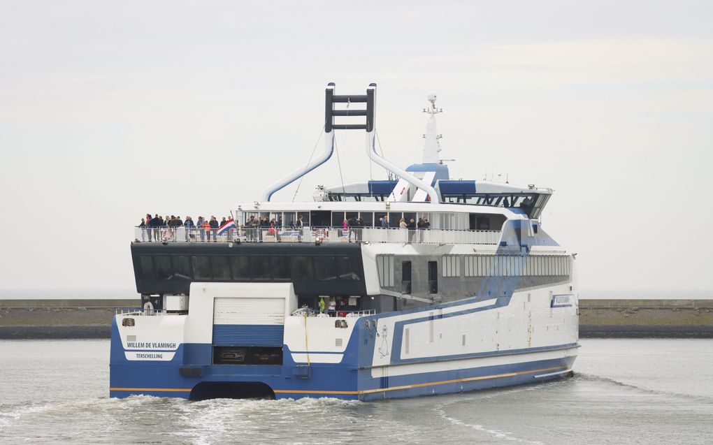 Een veerboot met de vlag half stok vertrekt uit de haven van Harlingen. Door de aanvaring tussen een snelboot en watertaxi bij Terschelling zijn twee mensen omgekomen. De zoekactie naar de twee vermisten is gestaakt. beeld ANP, Anton Kappers