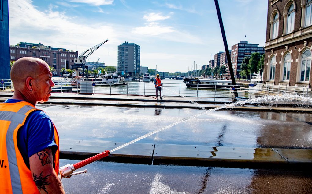 De Binnenhavenbrug in stadsdeel Feyenoord wordt natgehouden door medewerkers van de gemeente. De gemeente probeert hiermee te voorkomen dat stalen constructies teveel uitzetten door de warmte en daardoor klem komen te zitten. beeld ANP