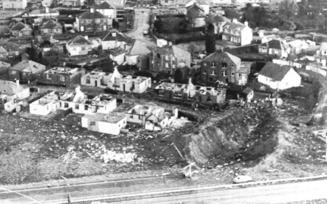 Luchtfoto van het Schotse plaatsje Lockerbie. Duidelijk is de krater (r) te zien die ontstond door de neerstortende Pan Am Boeing 747. Links van de krater verwoeste huizen en op de voorgrond de autoweg Carlisle-Glasgow. Foto EPA