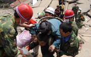 Chinese soldaten helpen in de door een zware aardbeving getroffen provincie Sichuan bij het zoeken naar overlevenden en het ruimen van het puin. Foto EPA