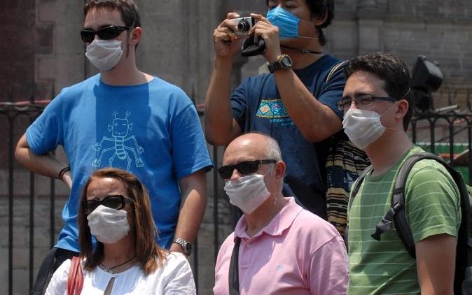 MEXICO CITY - Toeristen bekijken de bezienswaardigheden in Mexico City met mondkapjes op. Foto EPA