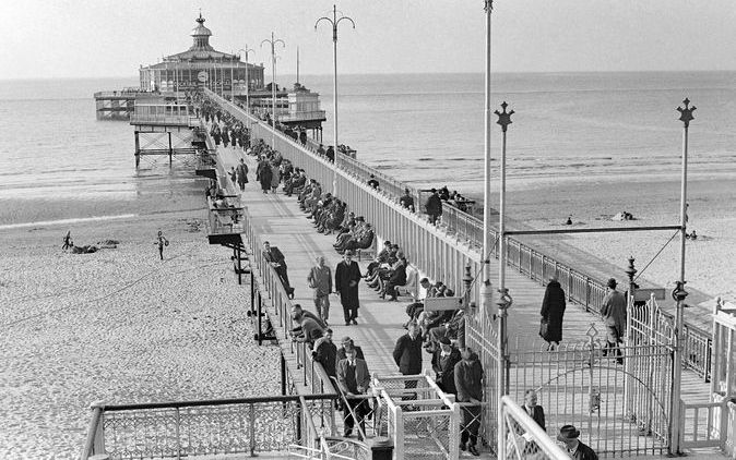 Historische foto van de pier van Scheveningen. Een nieuwe pier moet Scheveningen een nieuwe toekomst bieden. Wie de zee nadert, moet de kust kunnen zien. Om die blik mogelijk te maken, zal de gemeente Den Haag moeten slopen. Volgens de wethouders Peter Sm