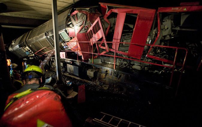 BARENDRECHT – Verwrongen staal, gekantelde zeecontainers, overal chaos. In de gecrashte locomotief een oranje kleed. Daaronder het lichaam van de omgekomen machinist. Voor hem komt de traumaheli te laat. Foto ANP