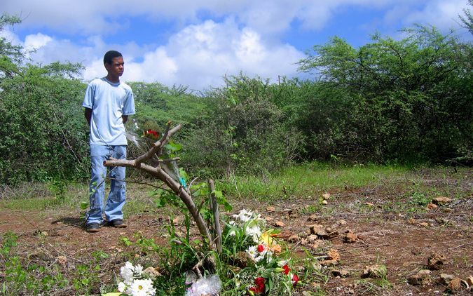 BONAIRE - Een jongen kijkt dinsdag naar de bloemen die bij de vindplek van het lichaam van Marlies van der Kouwe liggen. Het stoffelijk overschot van de 24-jarige apothekersassistente werd vrijdag gevonden in de wijk Amboina. De ouders van Marlies brachte