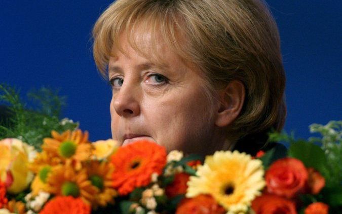 Merkel krijgt bloemen bij haar herverkiezing. Foto EPA