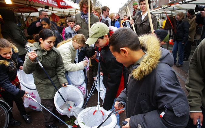 AMSTERDAM - Kinderen rapen zwerfafval op tijdens de Nederland Schoon-actie van vorig jaar. Foto ANP