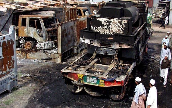 Uitgebrande trucks van de Navo, nadat gewapende mannen ze in brand hebben gestoken. Foto EPA