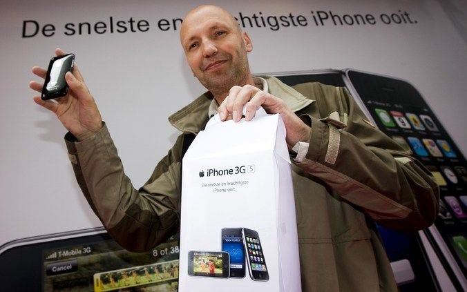 Een koper toont vrijdag zijn nieuwe iPhone in de T-Mobile winkel in Almere. Foto ANP