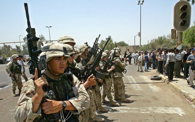 Amerikaanse soldaten houden voormalige Iraakse strijders in de gaten in Irak, juni 2003. Inmiddels wordt gesproken over een tijdpad van terugtrekking. Foto EPA