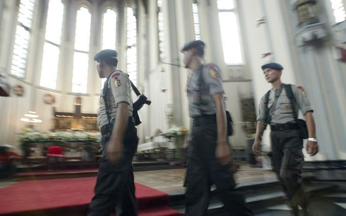 Politiemannen controleren een kerk in Jakarta, een aantal jaar geleden. Foto EPA