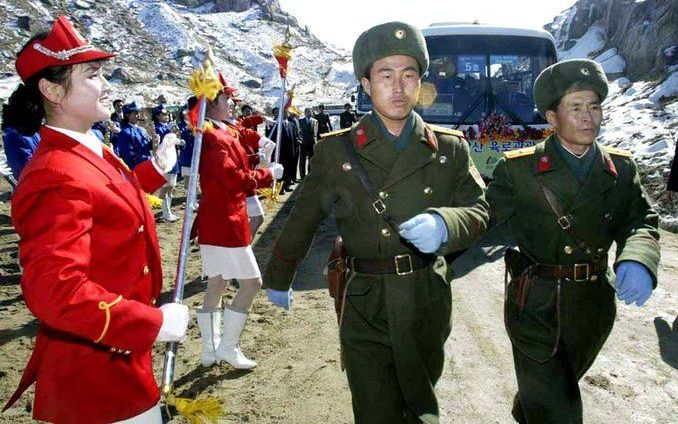 Noord-Koreaanse soldaten escorteren bussen van hun zuiderburen naar het vakantieoord. Foto EPA.