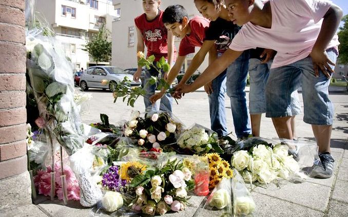 Buurtbewoners leggen bloemen voor de vermoorde Robiënna. Foto ANP