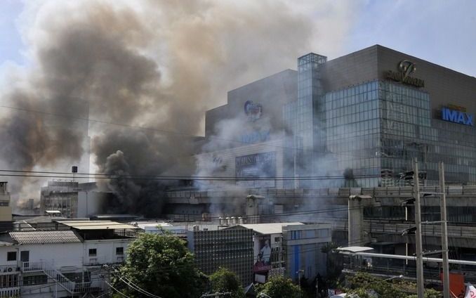 Zeker honderd mensen zijn bevrijd in het brandende complex van het Thaise tv–station Channel 3 in Bangkok. Dat meldde de Thaise brandweer. Foto EPA