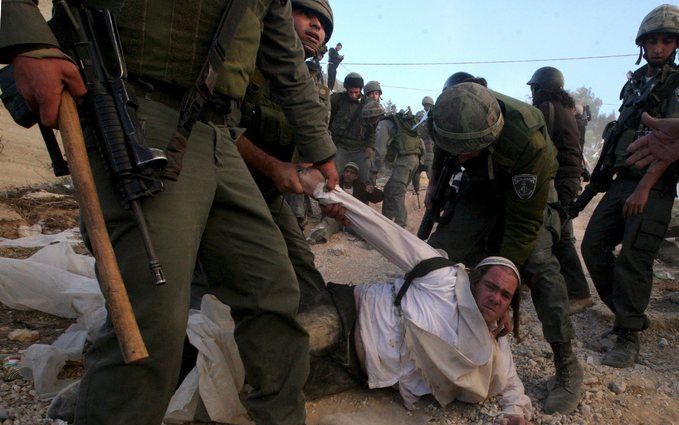 HEBRON – Israëlische soldaten sleepten gisteren een kolonist uit een woning in Hebron op de Westelijke Jordaanoever die bezet was door zo’n 250 ultraorthodoxe Joodse kolonisten. Ongeveer 20 mensen raakten bij de actie gewond. Foto EPA