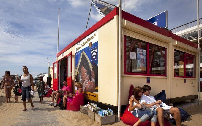 SCHEVENINGEN – Badgasten zijn verdiept in een boek uit de strandbibliotheek op het strand van Scheveningen. Foto's ANP