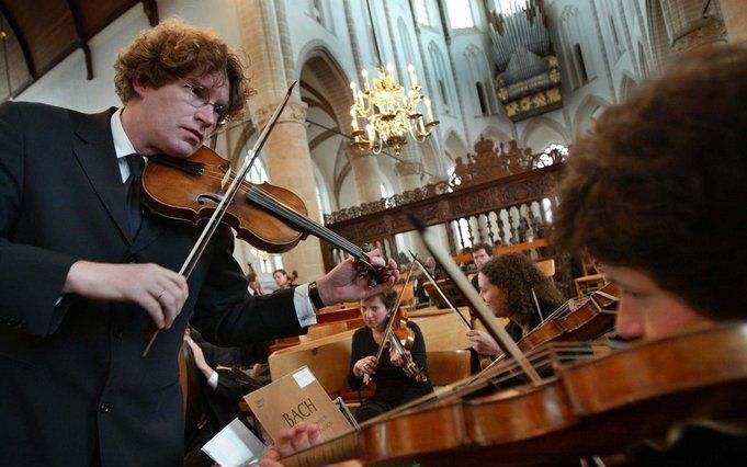 Musici stemmen hun instrumenten ter voorbereiding op de uitvoering van Bachs Matthäus Passion in de Grote Kerk van Naarden. Foto ANP