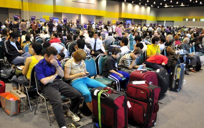 BANGKOK - Gestrandde reizigers wachten in Bangkok op wat komen gaat. Foto EPA