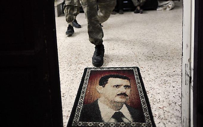 Portret van president Assad als deurmat. Foto EPA