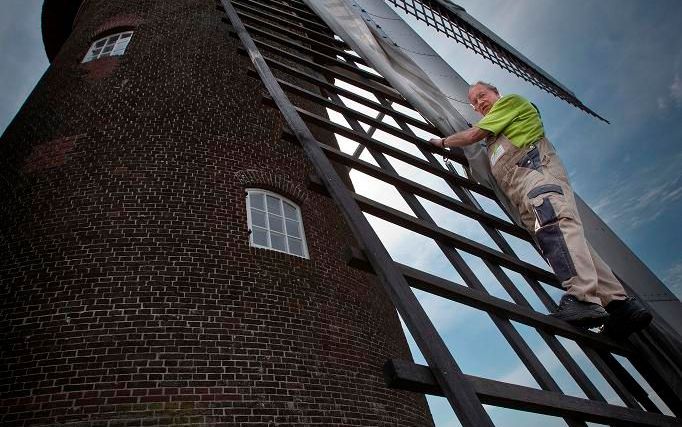 Molenaar Ben Brinkman (68) bevestigt de zeilen in de wieken van de molen Maallust in Amerongen. Voordat hij kan gaan malen, moet er heel wat gebeuren. Beeld RD, Henk Visscher