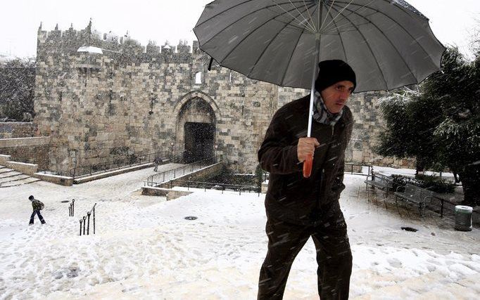 JERUZALEM – Een Palestijn passeert de Damascuspoort in Oost-Jeruzalem. Als gevolg van een sneeuwstorm was de Israëlische hoofdstad woensdag bedekt met een wit deken van zo’n 20 centimeter. Foto EPA