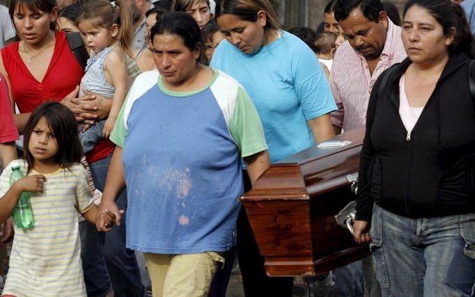 BUENOS AIRES - Mirta del Carmen Ortega (links), draagt samen met enkele familieleden de kist van haar twee jaar oude dochtertje Milagros, tijdens de begrafenis maandag in Buenos Aires. Het meisje werd zondag dood gevonden, vlak bij haar huis. Volgens de p