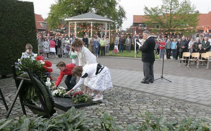 WAARDE – Kinderen leggen een krans bij het oorlogsmonument in Waarde. Daar werden zaterdagavond de slachtoffers van de Tweede Wereldoorlog herdacht. In 1944 stortte een bommenwerper in het dorpje op Zuid Beveland neer. FotoL: Duo Foto