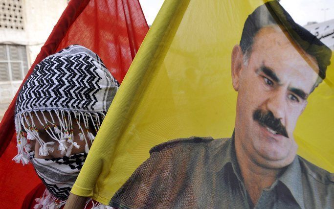 DEN HAAG - Koerdische demonstranten dragen een vlag met een afbeelding van Adullah Öcalan. Foto EPA