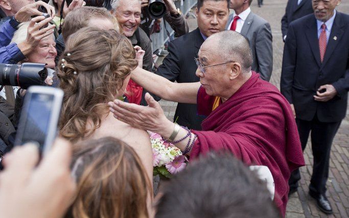 Een pasgetrouwd stel krijgt een zegen van de dalai lama bij zijn vertrek op het Binnenhof in Den Haag. Foto ANP