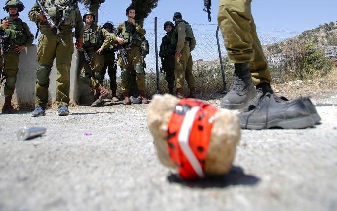 GUSH ETZION. Israëlische militairen staan bij de plaats waar een Palestijn twee soldaten neerstak. Een van de gewonden schoot vervolgens de terrorist neer. beeld Abed al-Hashlamun