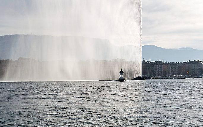 Een man zwemt maandag, een dag voor kerst, in het Meer van Genève. Foto EPA