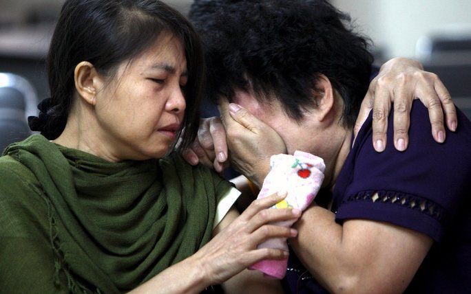 Vrouwen huilen om het verlies van een slachtoffer van een brand in een nachtclub in de Thaise hoofdstad Bangkok, waar honderden mensen oudejaarsavond vierden. Foto EPA