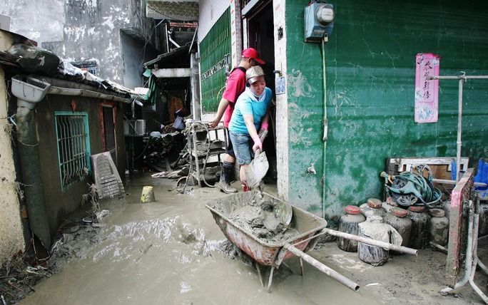 In het zuiden van Taiwan maken mensen hun huizen schoon nadat tyfoon Morakot huis heeft gehouden. Foto EPA