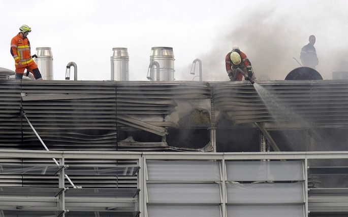 BRUSSEL – Uit de bovenste etages van het Berlaymont–gebouw kwamen dikke zwarte stinkende rookwolken. De brand, die inmiddels onder controle is, trof de technische ruimtes vol kabels op de dertiende en veertiende verdieping van het gebouw. Foto EPA