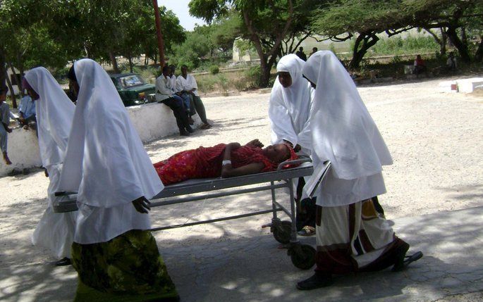 Zusters in Somalië vervoeren een gewonde vrouw na een bomaanslag, zaterdag in Mogadishu. Foto EPA