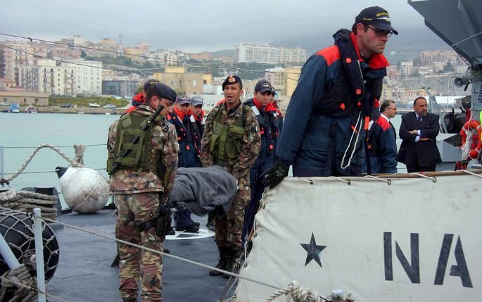 Een Italiaans marineschip neemt vluchtelingen van een Turks vrachtschip aan boord. Foto EPA