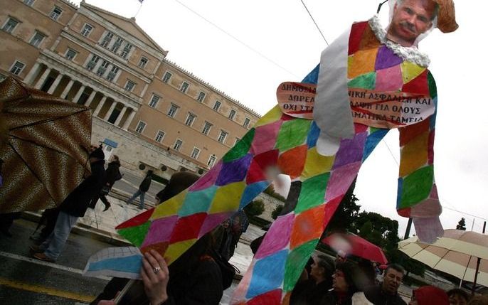 Demonstranten tonen woensdag een beeltenis van premier Papandreou. Foto EPA