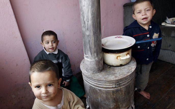 Roma-kinderen rond een gasfornuis in Mitrovica. Foto EPA