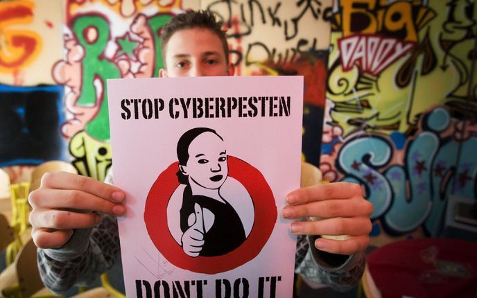 AMSTERDAM - Een leerling met zijn poster tegen het Cyberpesten maandag bij school De Wissel in Amsterdam. Met deze toast is het lesprogramma over cyberpesten afgesloten en is de school uitgeroepen tot pestvrij. Foto ANP