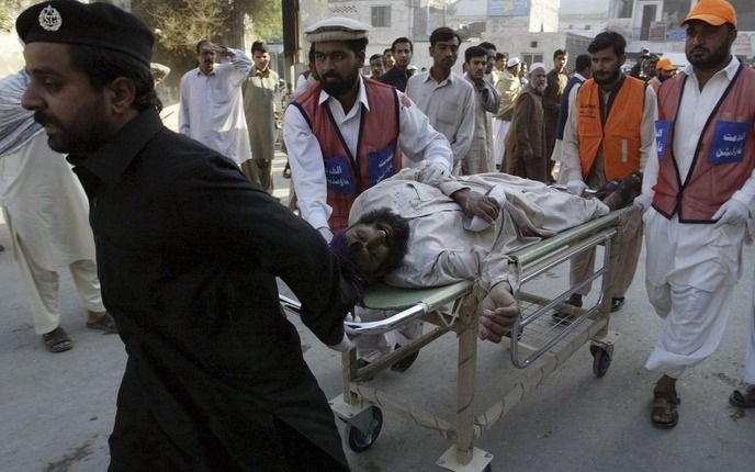 Een gewonde wordt afgevoerd na een bomaanslag in Peshawar. Foto EPA