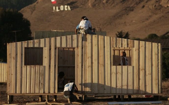 Vrijwilligers bouwen in Iloca, Chili, aan nieuwe houten huizen voor de slachtoffers van de aardbeving met een kracht van 8,8 op de schaal van Richter die het land op 27 februari trof. Foto EPA.