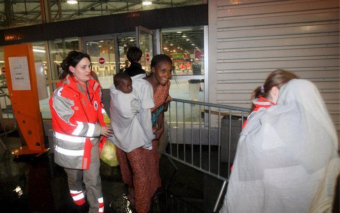 PARIJS - Medewerkers van het Rode Kruis begeleiden op het Parijse vliegveld Charles de Gaulle een groep Fransen die zijn geevacueerd uit Tsjaad. Foto EPA