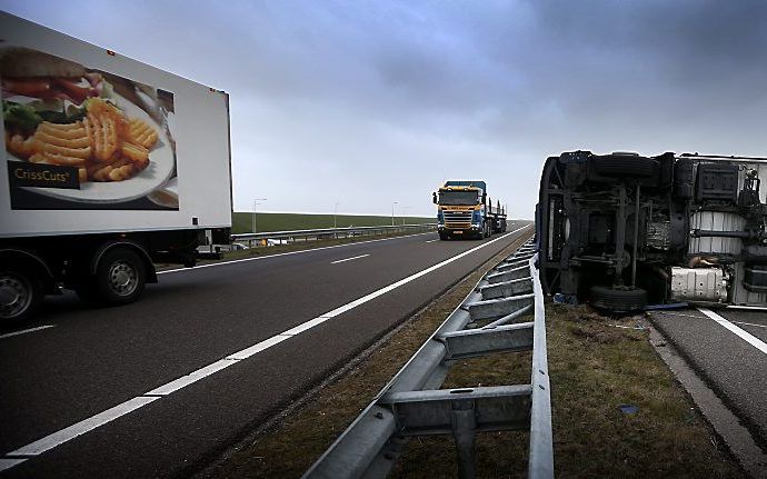 Een omgewaaide vrachtwagen dinsdag op de N31 bij Harlingen. Beeld ANP