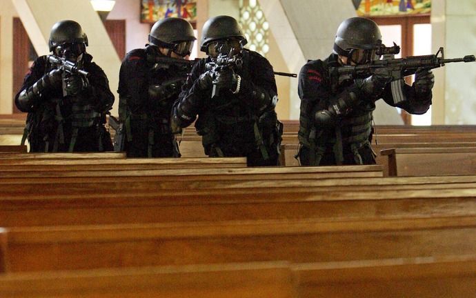 JAKARTA - De overheid moet volgens bisschop Pujasumarta moslims harder aanpakken. Op de foto een politieeenheid in een Indonesische kerk. Foto EPA