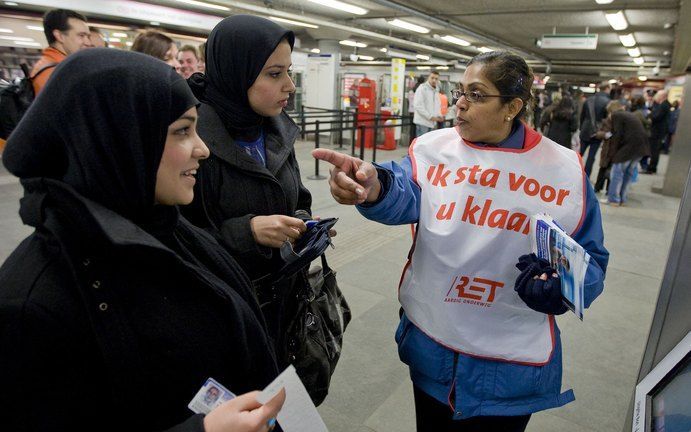 Een RET-medewerker helpt donderdagochtend een klant . De Rotterdamse RET doet vanaf donderdag in de metro als eerste openbaar vervoerbedrijf van Nederland de strippenkaart in de ban. Reizigers kunnen alleen nog met de ov-chipkaart reizen. ANP PHOTO ED OUD