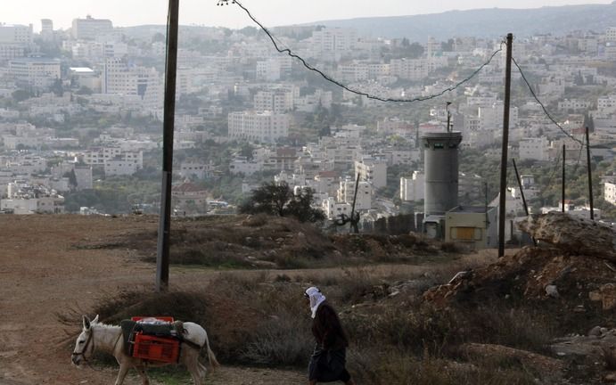 „Volkenrechtelijk kan niet zo maar worden gezegd dat de Westoever door Israël is „bezet.” De rechtsgeleerde Eugene Rostov spreekt dan ook liever van een „niet toegewezen gebied.”” Foto: een Israëlische wachtpost met uitzicht op de stad Bethlehem op de Wes