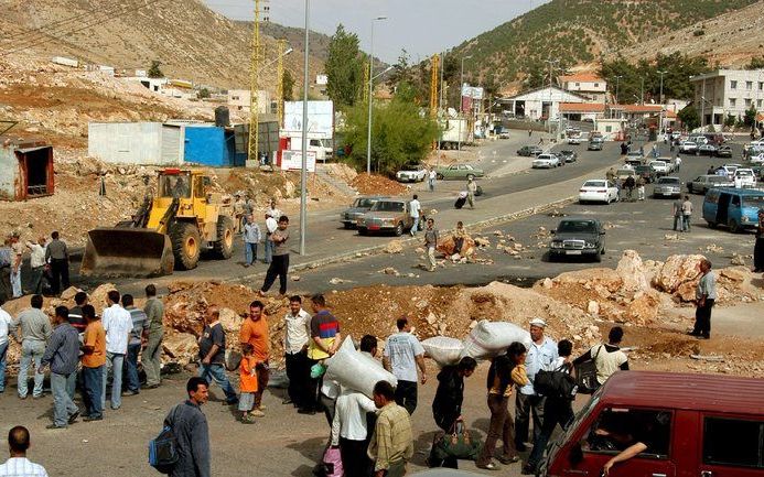 LIBANON - In het zuiden van Libanon zijn roadblocks aangelegd waardoor mensen hun bagage ter hand nemen en te voet verder gaan. Foto EPA