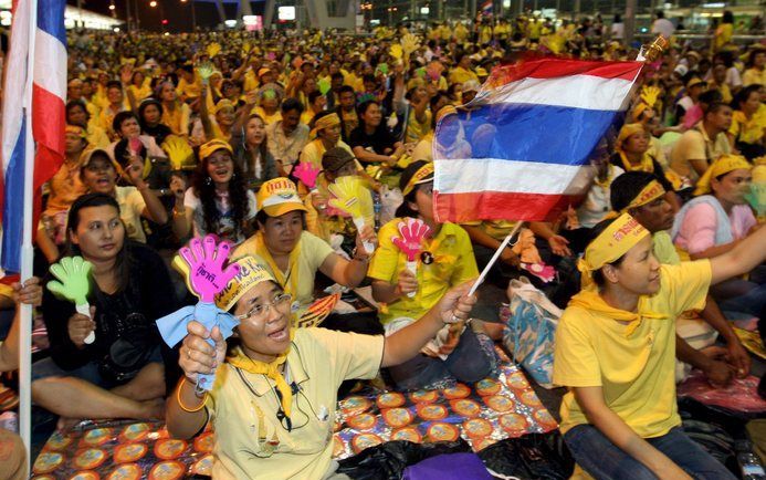 Duizenden demonstranten roepen leuzen tegen de Thaise regering op het vliegveld van Bangkok. Foto EPA