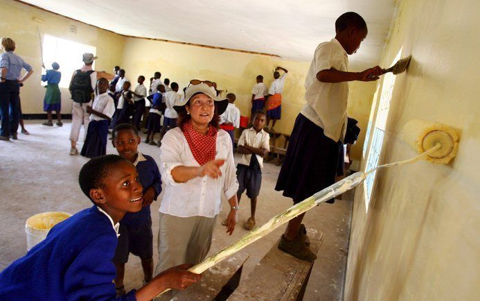 Amerikanen helpen kinderen in Tanzania met het verven van een schoollokaal. Foto EPA