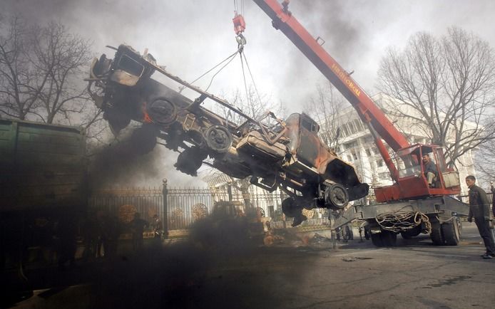 Een uitgebrande truck wordt weggetakeld in Bishkek. Foto EPA