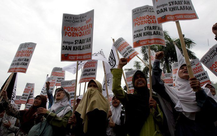 JAKARTA - Indonesische moslims protesteren in Jakarta ter ondersteuning van een omstreden anti-pornowet. De wet werd gisteren door het Indonesische parlement aangenomen. Foto EPA